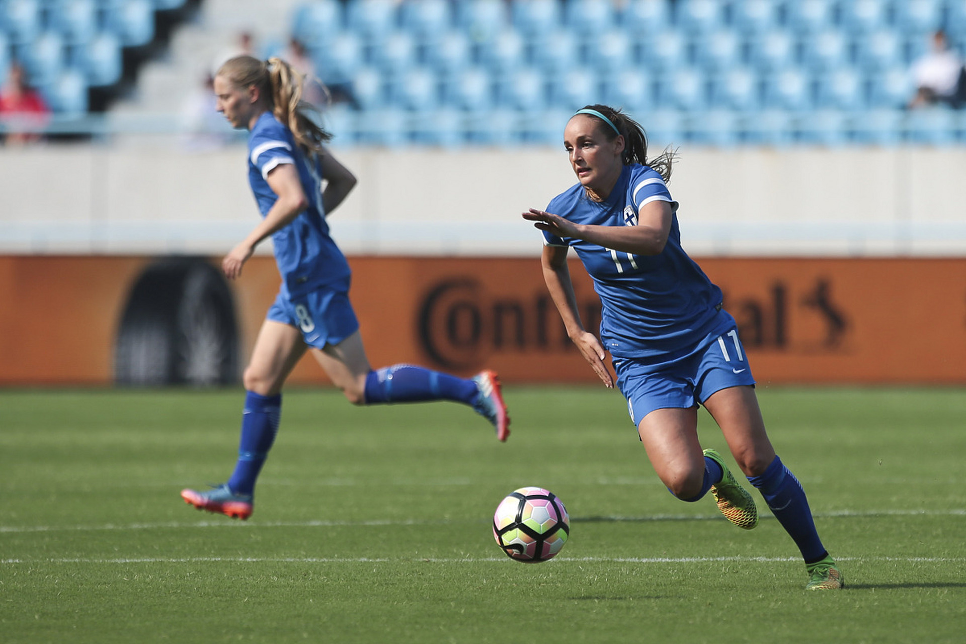 芬兰女足队在赛场上穿梭跑动，展现出色表现